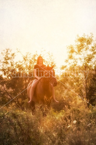 Young woman horseback riding bareback in the setting sun