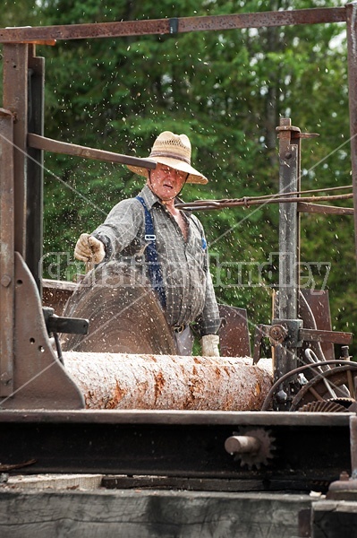 Man operating a circular saw mill on the farm