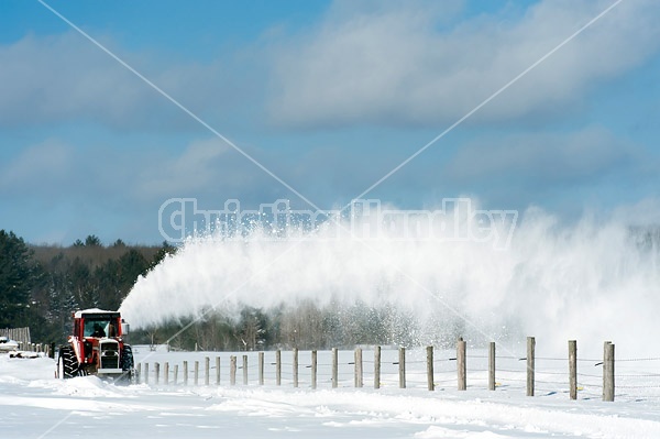 Snow blowing a road with tractor