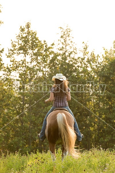 Young woman horseback riding western 