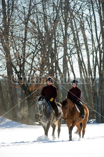 Husband and wife horseback riding through the deep snow