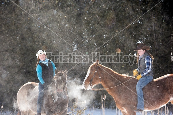 Two young woman riding horses bareback through deep snow