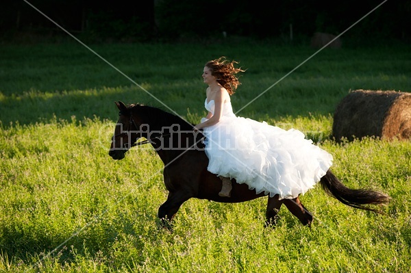 Woman riding horse wearing a wedding dress