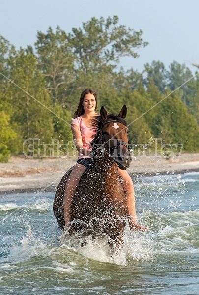 Young woman horseback riding in Lake Ontario