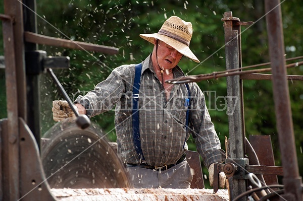 Man operating a circular saw mill on the farm