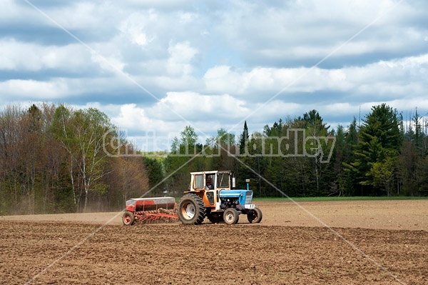 Farmer seeding newly worked up field