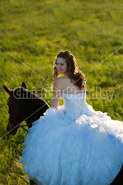 Woman riding horse wearing a wedding dress