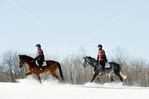 Husband and wife horseback riding through the deep snow