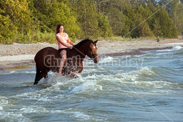 Young woman horseback riding in Lake Ontario