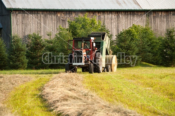 Farmer round baling hay