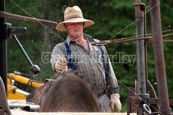 Man operating a circular saw mill on the farm