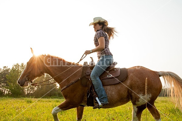 Young woman horseback riding western 