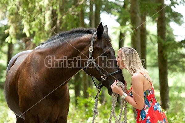 Young woman with her dark bay horse