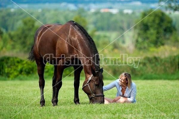 Young woman with her dark bay horse