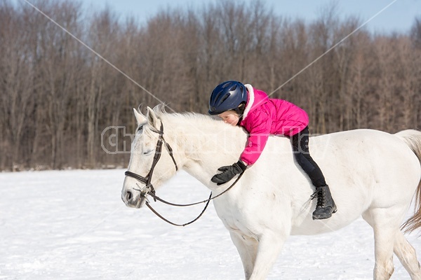 Young girl riding her pony bareback in the winter. 