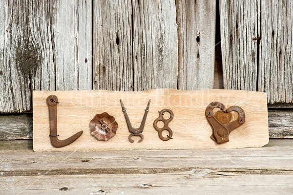 Hand crafted Love art sign made out of wood and recycled or repurposed farm tools and machinery parts
