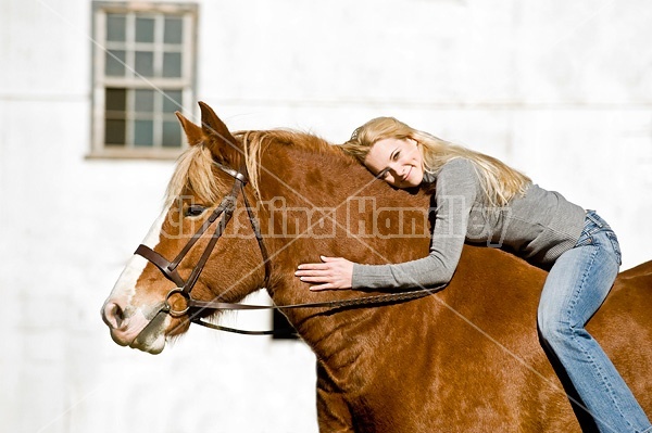 Young woman riding Belgian horse bareback.