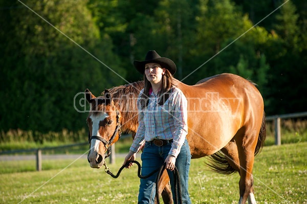 Young woman catching her Paint mare out of the paddock