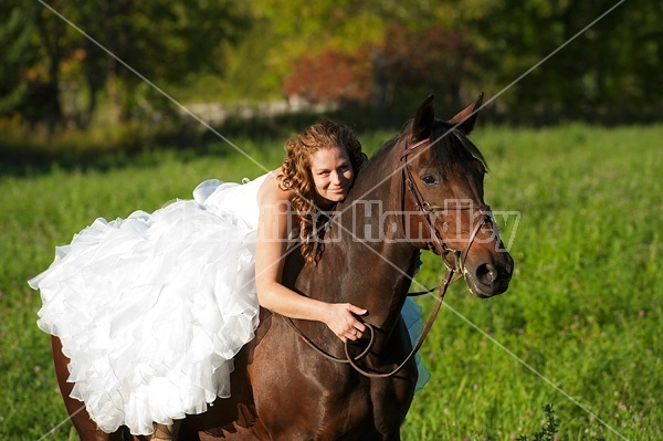 Woman riding horse wearing a wedding dress