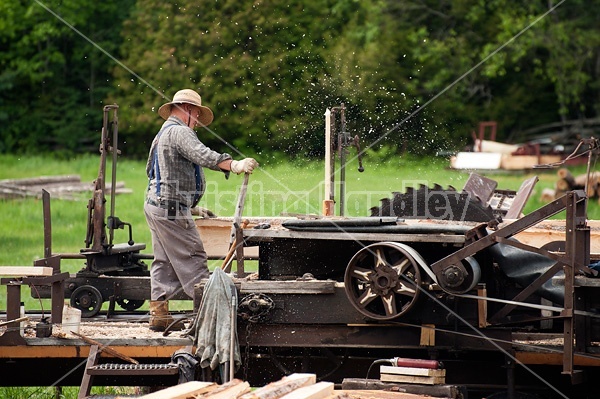 Man operating a circular saw mill on the farm