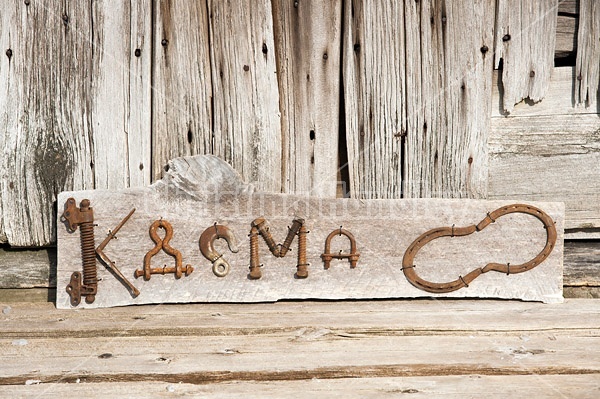 Hand crafted Karma art sign made out of wood and recycled or repurposed farm tools and machinery parts