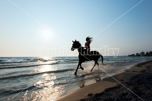 Silhouette photo of woman riding a horse bareback.