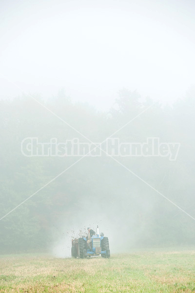 Spreading manure in the early morning fog