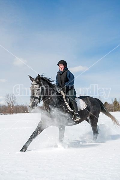 Woman riding Hanoverian mare in deep snow