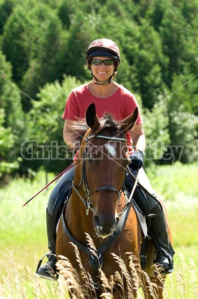 Woman horseback riding in field