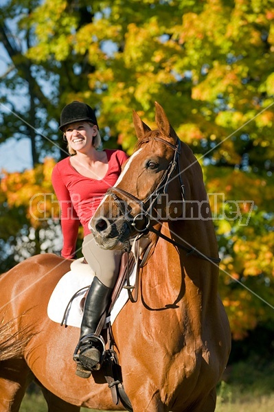 Young woman horseback riding in the fall of the year.