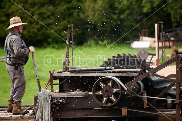 Man operating a circular saw mill on the farm