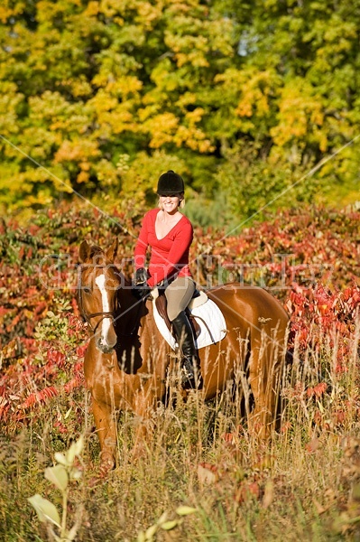 Young woman horseback riding in the fall of the year.