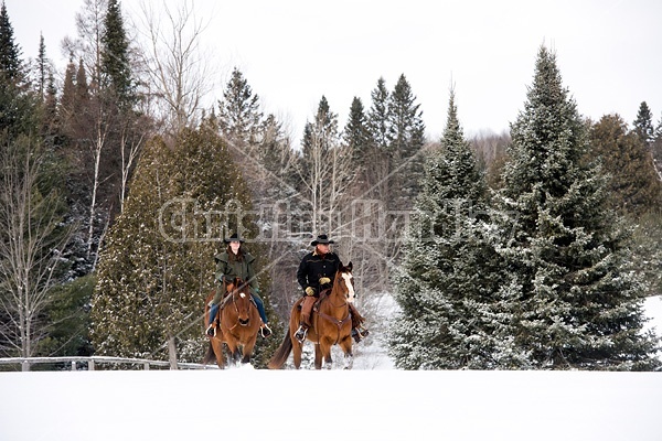 Man and woman horseback riding in the snow