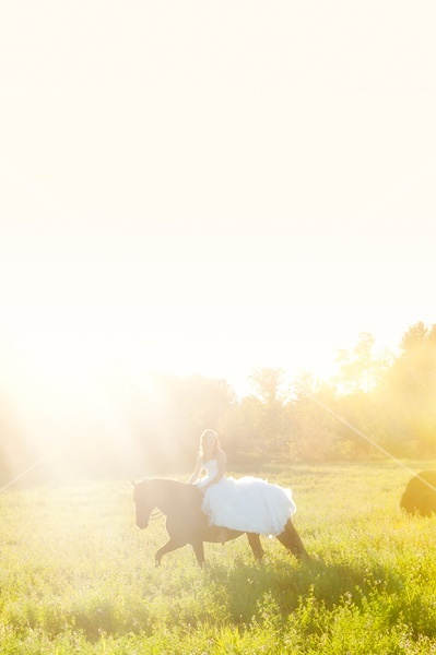 Woman riding horse wearing a wedding dress