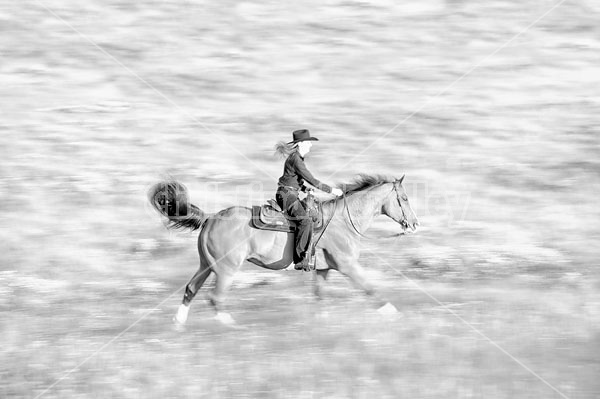 Young woman riding her American Paint horse mare