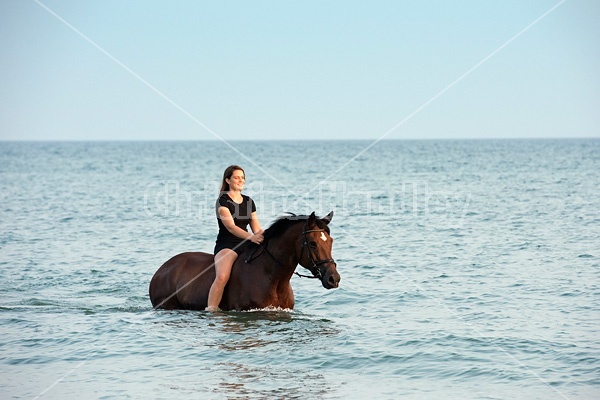 Young woman horseback riding in Lake Ontario