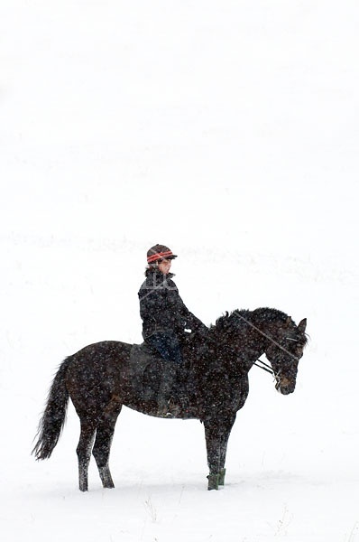 Woman horseback riding in the winter
