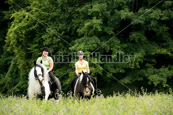 Two women riding Gypsy Vanner horses