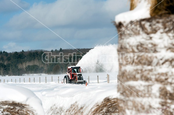 Snow blowing a road with tractor