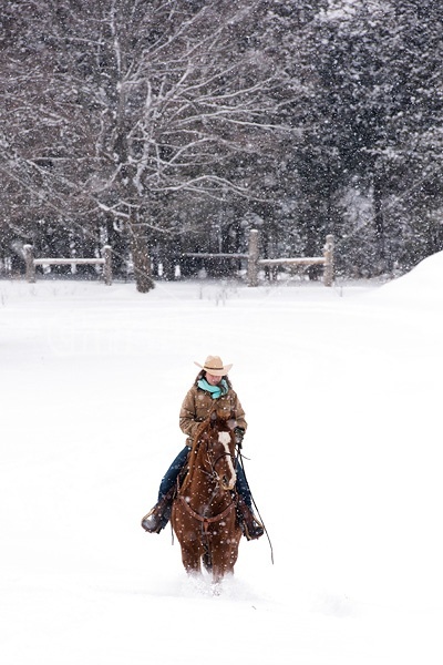 Young woman riding horse in snowstorm in Ontario Canada