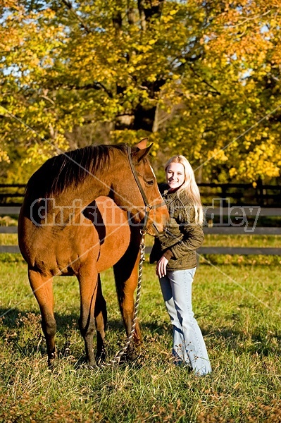 Woman with horse in pasture