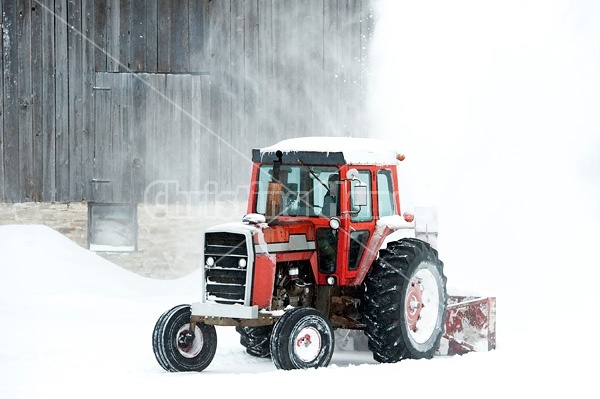 Snow blowing around the farm with a tractor and snow blower