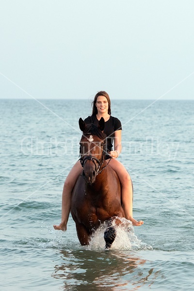 Young woman horseback riding in Lake Ontario