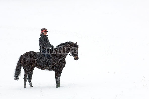 Woman horseback riding in the winter