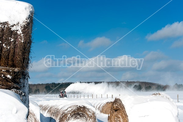 Snow blowing a road with tractor