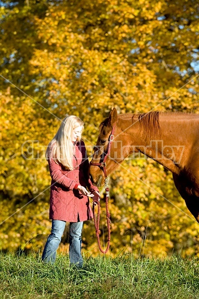 Woman with horse in pasture