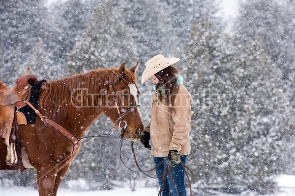 Young womand with horse in the snow