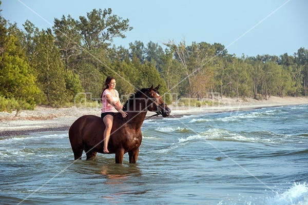 Young woman horseback riding in Lake Ontario