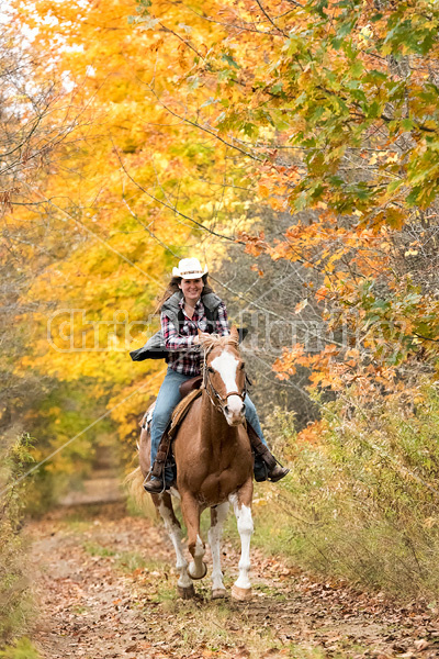 Young woman riding Paint horse 
