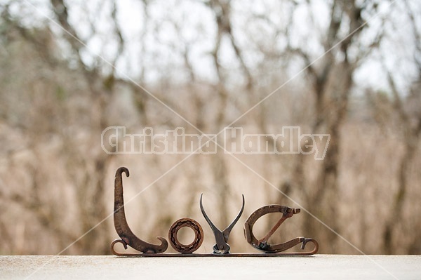 Hand crafted Love art sign made out of recycled or repurposed farm tools and machinery parts